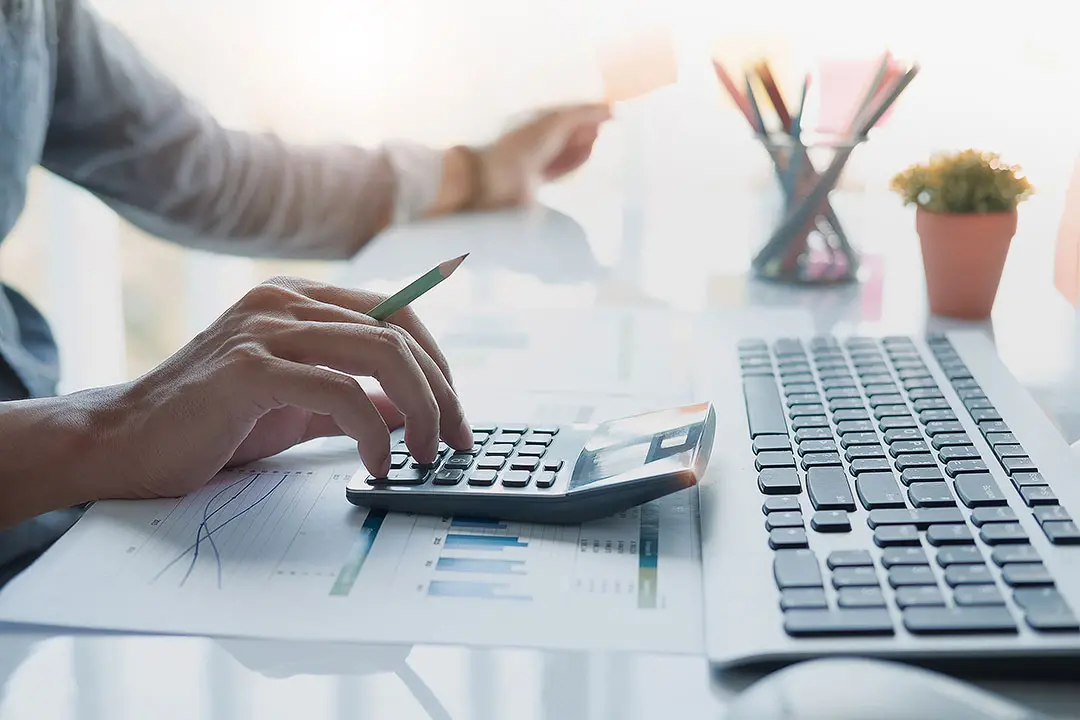 https://images.class.atexcloud.io/view/acePublic/alias/contentid/6276d84b-38a8-4cc3-957a-de4798bceac3/0/close-up-of-businessman-or-accountant-hand-holding-pencil-working-on-calculator-to-calculate-financial-data-report-accountancy-document-and-laptop-computer-at-office-business-concept.webp